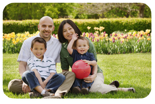 mom and dad in the park during spring with their young boys
