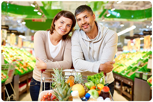 An adult couple grocery shopping together